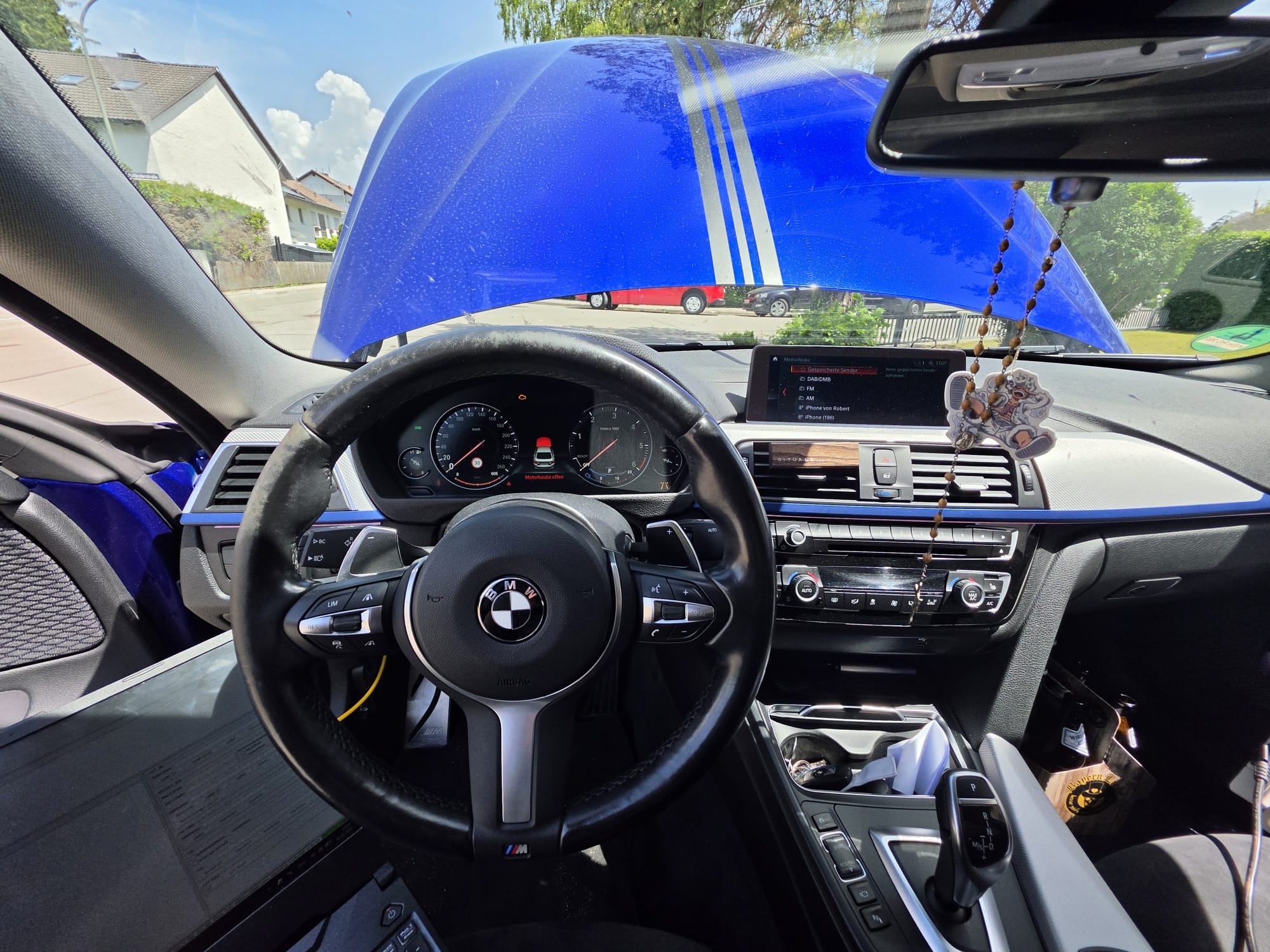 BMW-Cockpit mit blauem Fahrzeug und Infotainment-Display